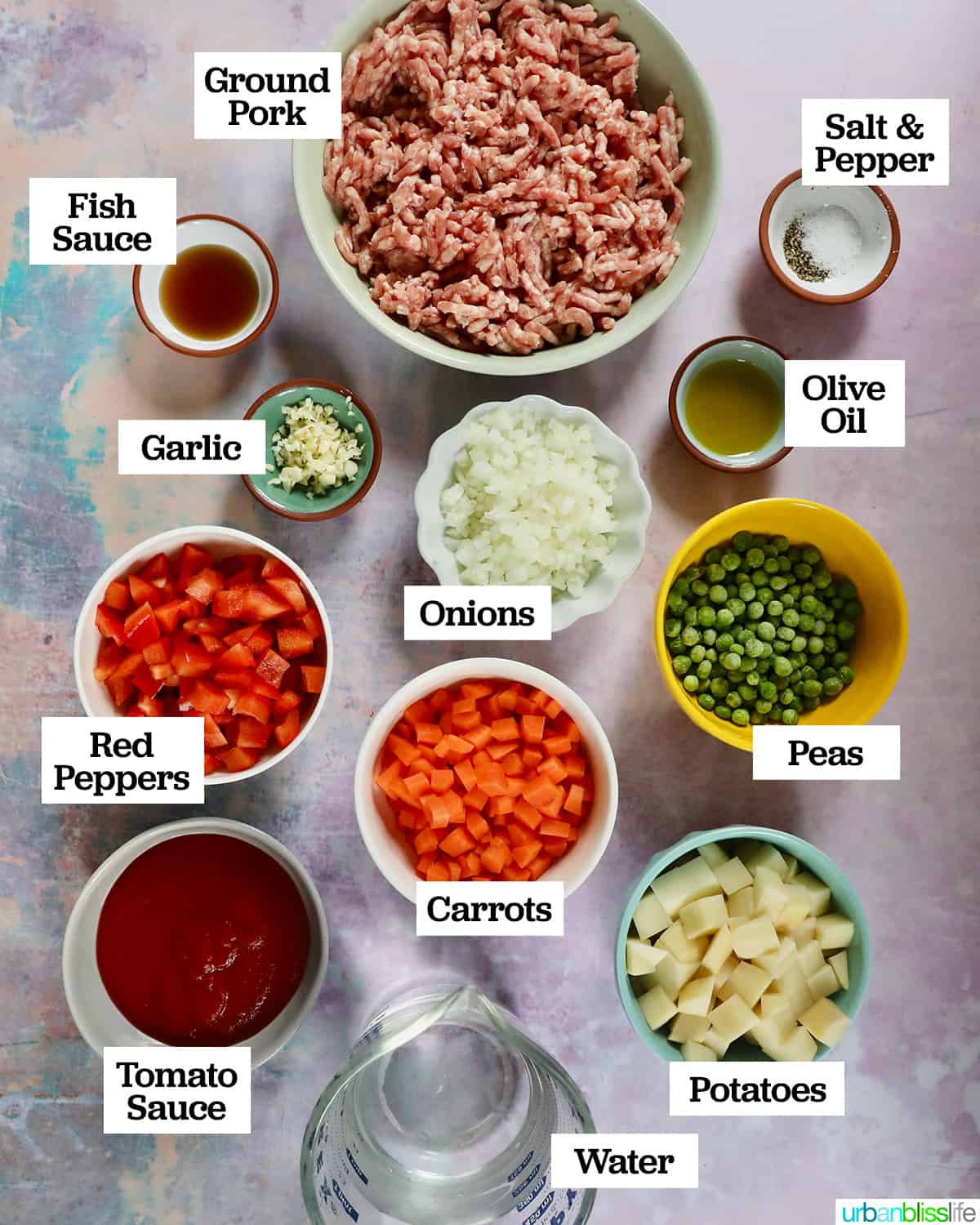 bowls of ingredients to make ground pork menudo on a pastel colored table