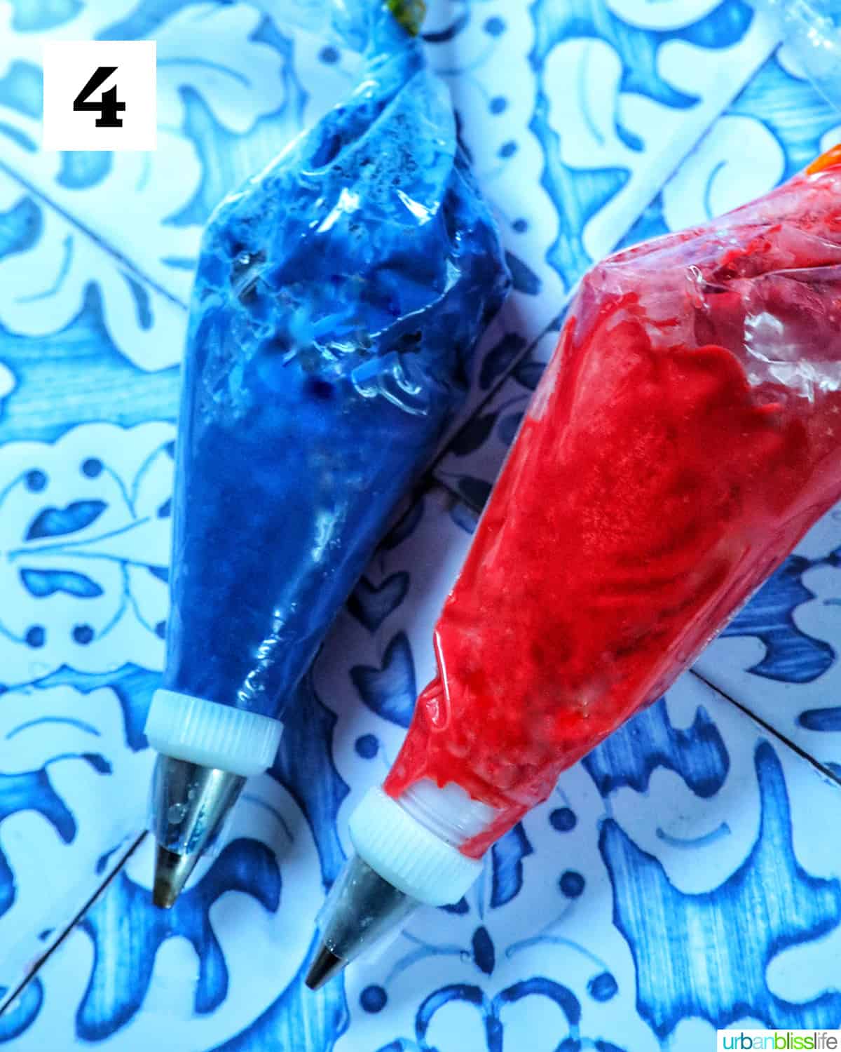 red and blue candy melts melted and in piping bags on a blue and white table.