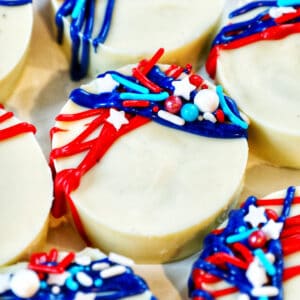 several red, white, and blue chocolate covered 4th of July Oreos with star sprinkles.