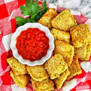 air fryer ravioli with marinara sauce and parsley.