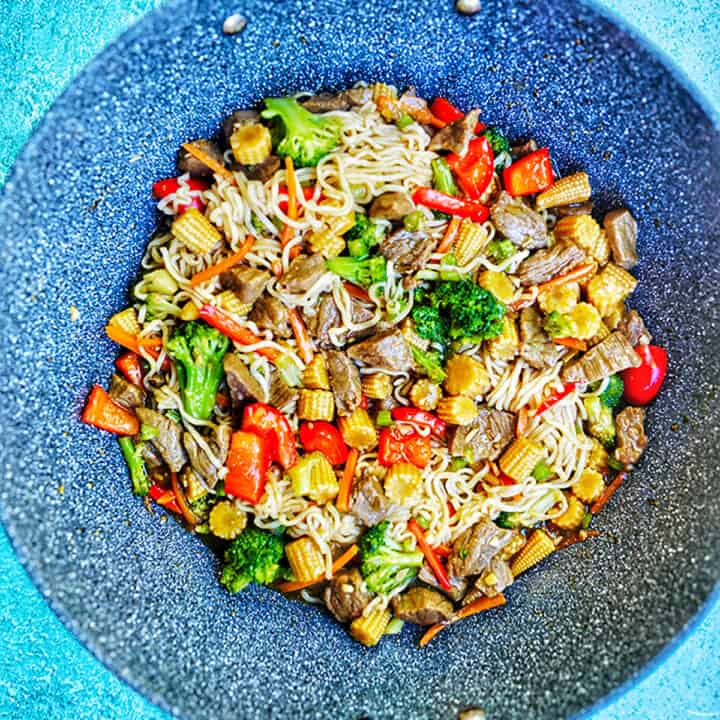 beef lo mein noodles with veggies in a wok.