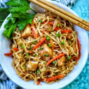 chicken yakisoba with chopsticks and parsley.