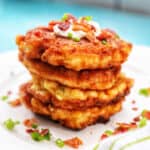 two corn fritters in a stack.