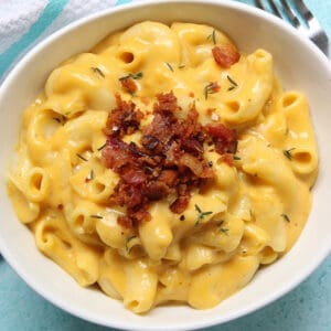 creamy dairy-free mac and cheese topped with crispy bacon bits.