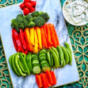 christmas tree veggie tray with bell pepper slices, broccoli, cucumbers, and carrots.