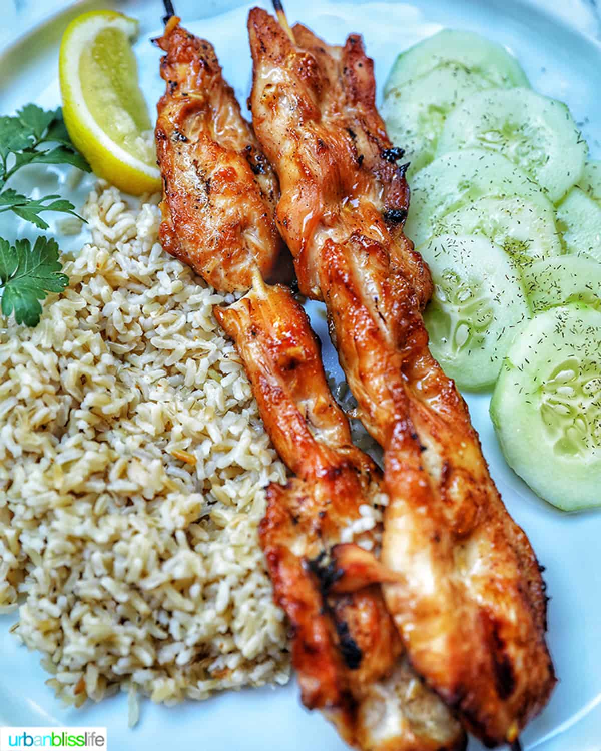 honey garlic chicken skewers with rice and cucumber salad.
