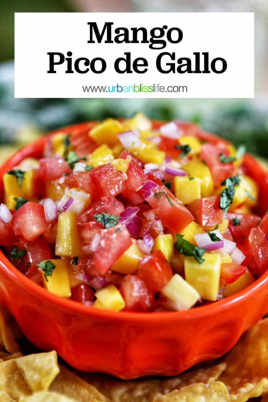 Mango pico de gallo in orange bowl surrounded by tortilla chips with text overlay.