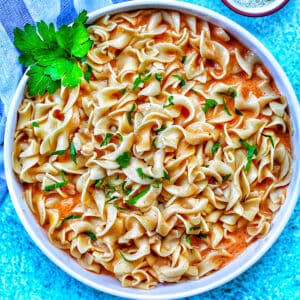 paprika pasta in white bowl with blue background.