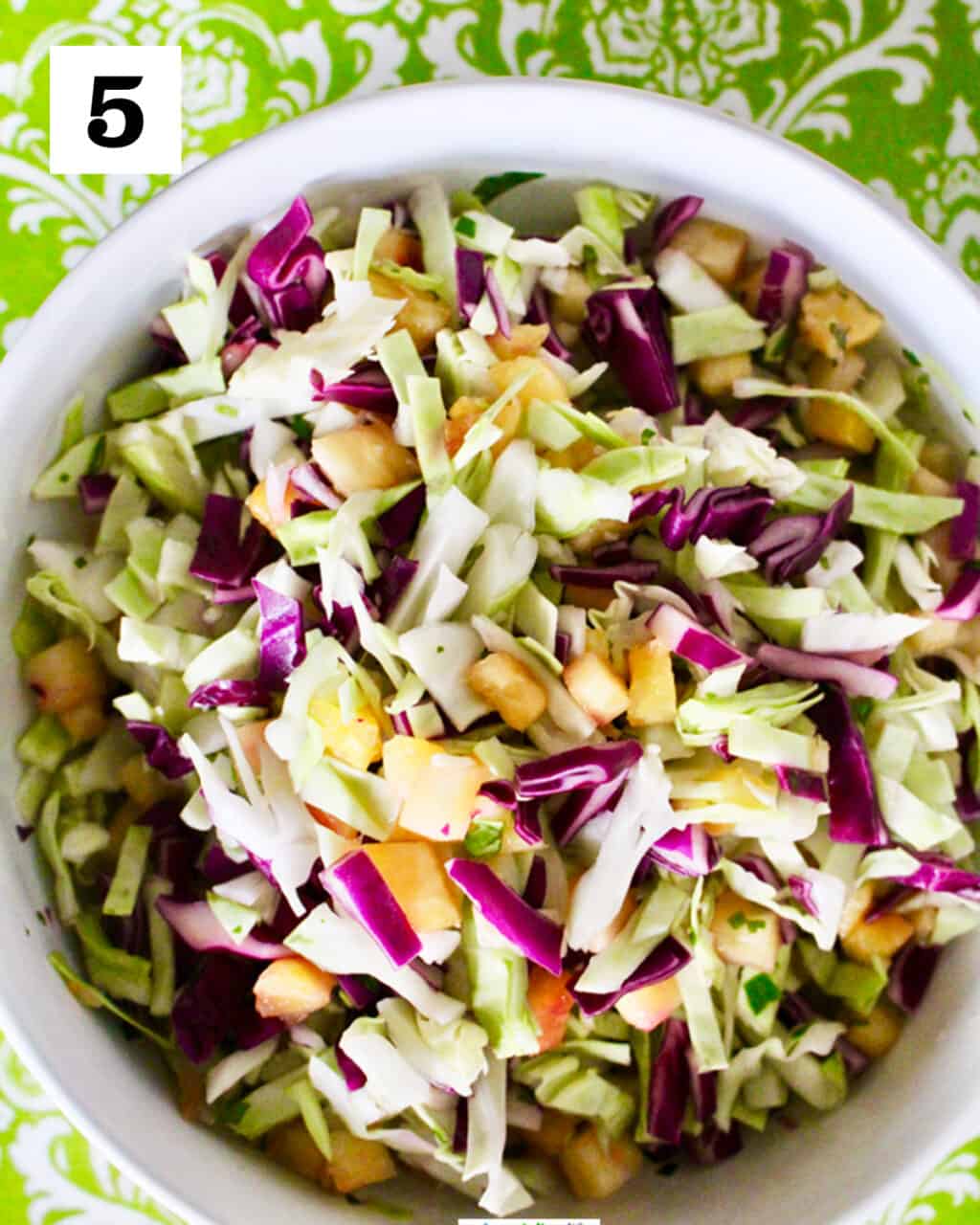 pineapple slaw with cabbage and cilantro in a white bowl.
