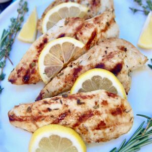 lemon grilled chicken with herbs on a platter.