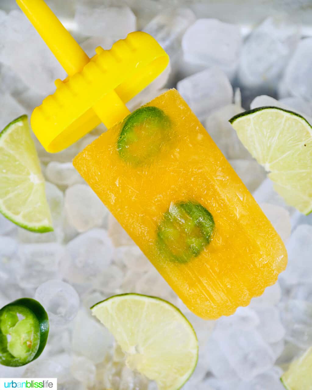 yellow margarita popsicle over a bed of ice with popsicle stick partway out.
