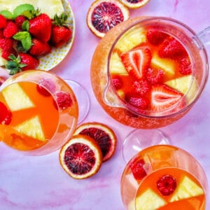 tropical rosé sangria in three glasses with blood orange slices.