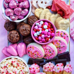 valentine's day chocolate dessert board with chocolate bites, m&ms, and pink cookies.