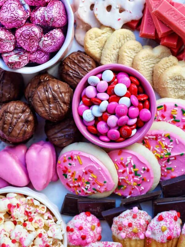 valentine's day chocolate dessert board with chocolate bites, m&ms, and pink cookies.