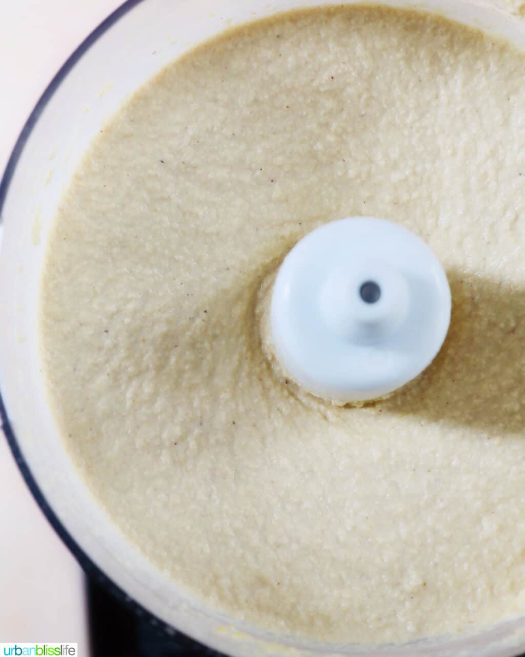 closeup of Vegan Cashew Cheese blended smoothly in a food processor.