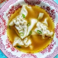 wonton noodle soup in red and white bowl.