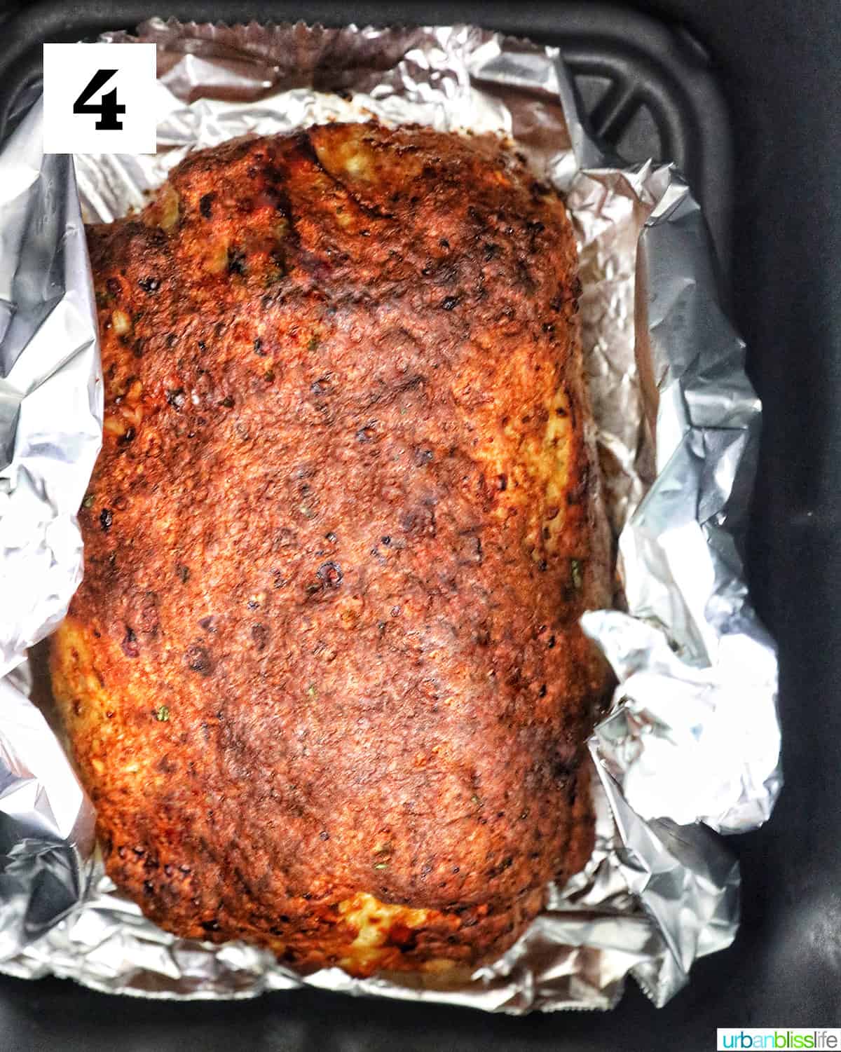 meatloaf on top of aluminum foil in an air fryer.