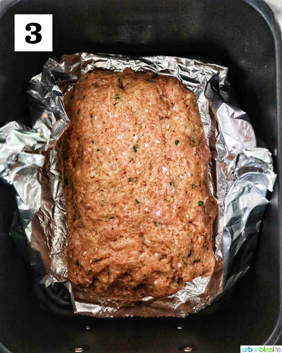 meatloaf on top of aluminum foil in an air fryer.