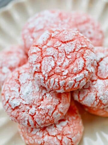 strawberry crinkle cookies stacked in a white plate.