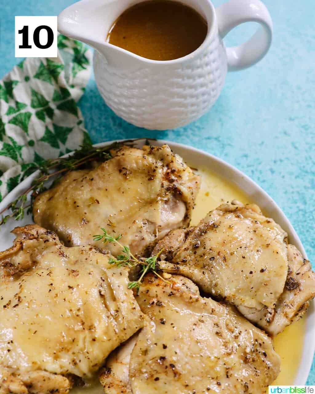 four instant pot chicken thighs on a white plate with green napkin and blue background and gravy.