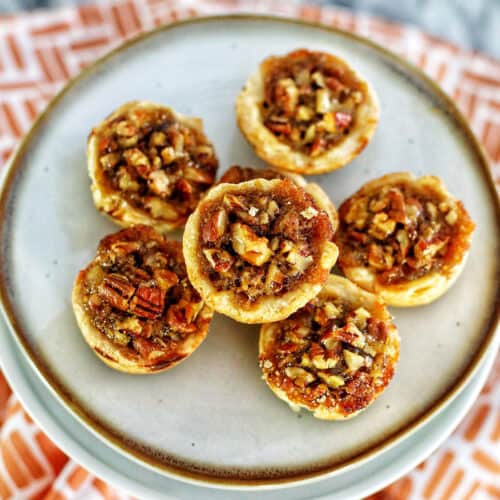 several mini pecan pies on a plate.