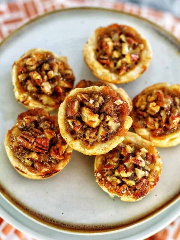 several mini pecan pies on a plate.