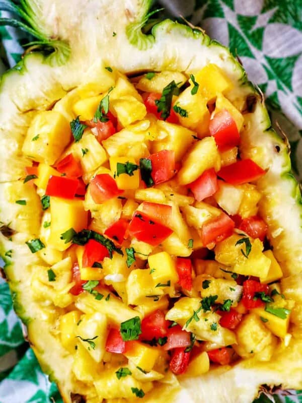 chopped pineapple, mango, tomatoes, and onions in a hollowed out pineapple.