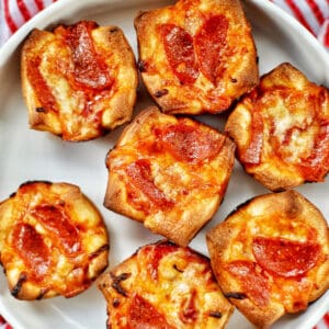 several mini pepperoni pizza cups on a plate.
