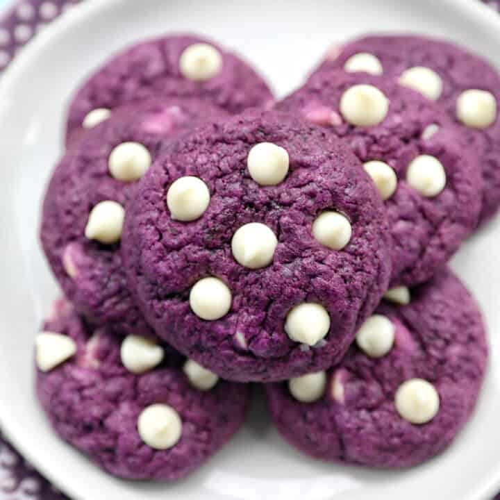 white chocolate chip ube cookies on a plate.