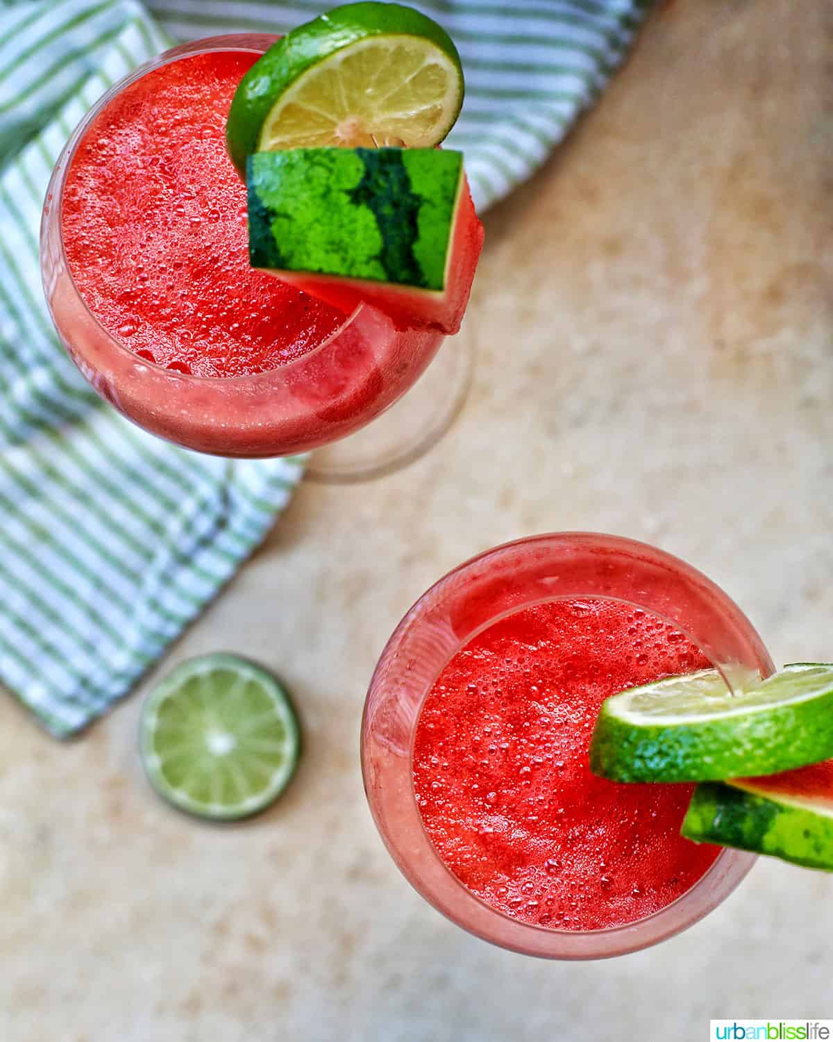 overhead look at two glasses of watermelon mimosas with watermelon and lime slice garnishes.