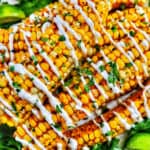 closeup photo of air fryer corn ribs stacked on top of one another with drizzled mayo and chopped cilantro.