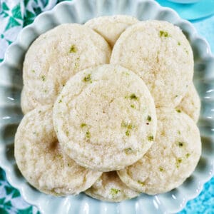 several key lime cookies stacked on a plate.