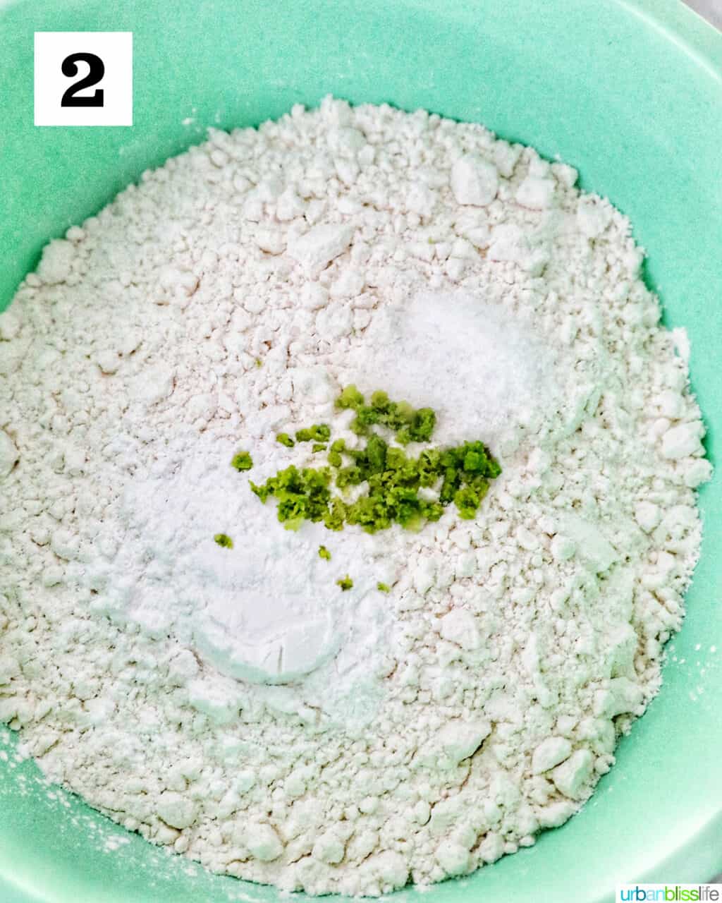 green bowl filled with flour, baking powder, salt, and key lime zest.
