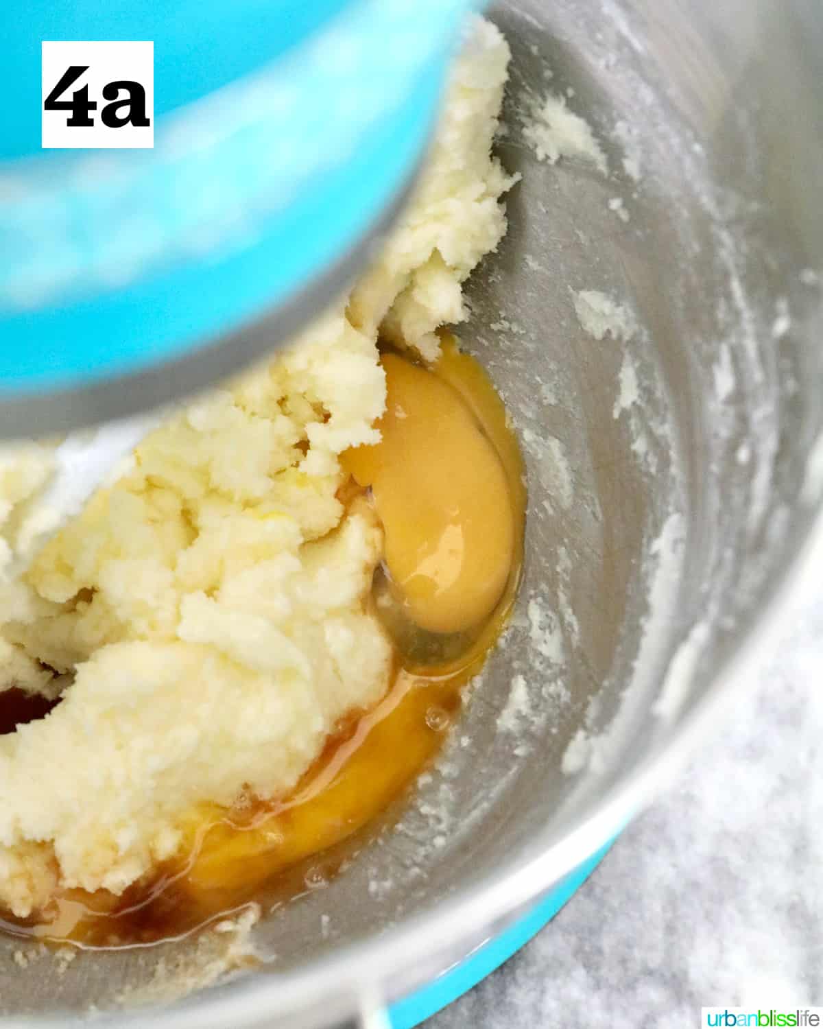 adding eggs to batter to make key lime sugar cookies in a stand mixer.