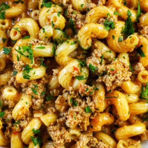 closeup of bowl of dairy free one pot cheeseburger pasta with ground turkey and chopped parsley.