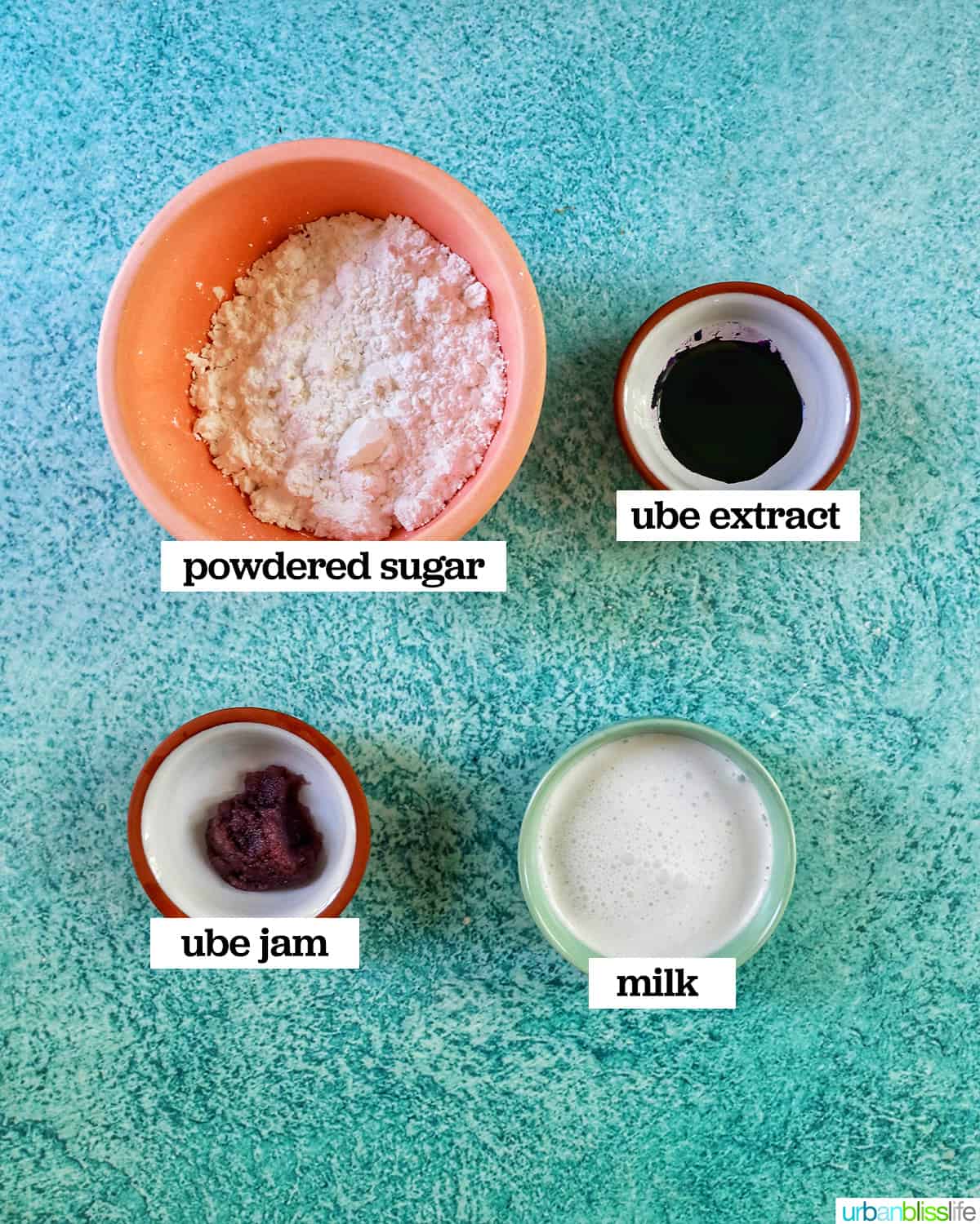 four bowls of ingredients to make ube glaze on a blue background.