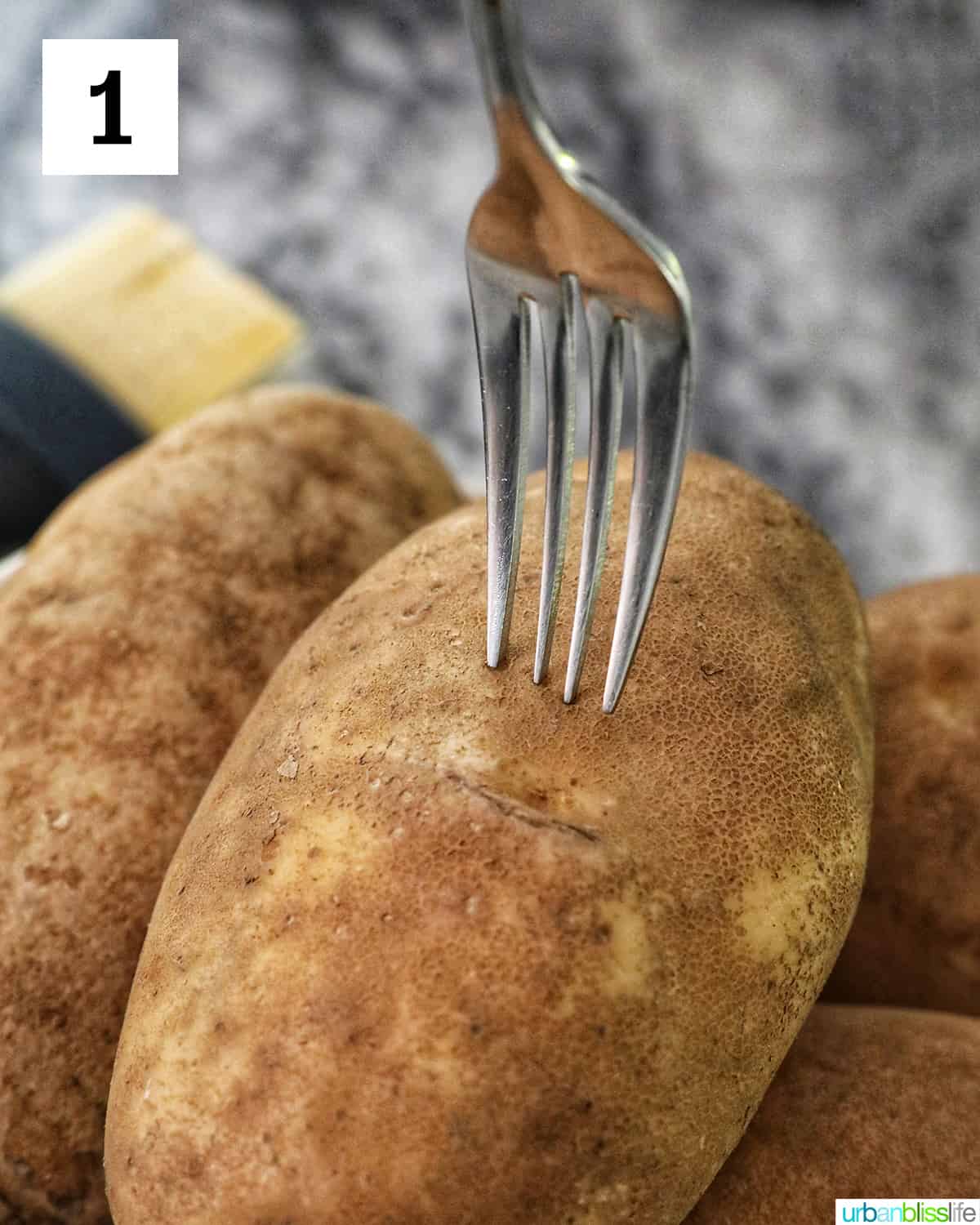 a fork piercing the center of a baking potato.