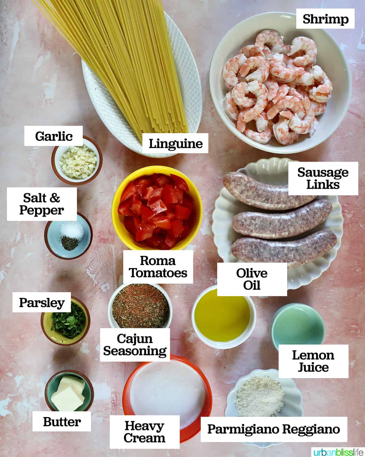 bowls and plates full of individual ingredients to make shrimp and sausage pasta.