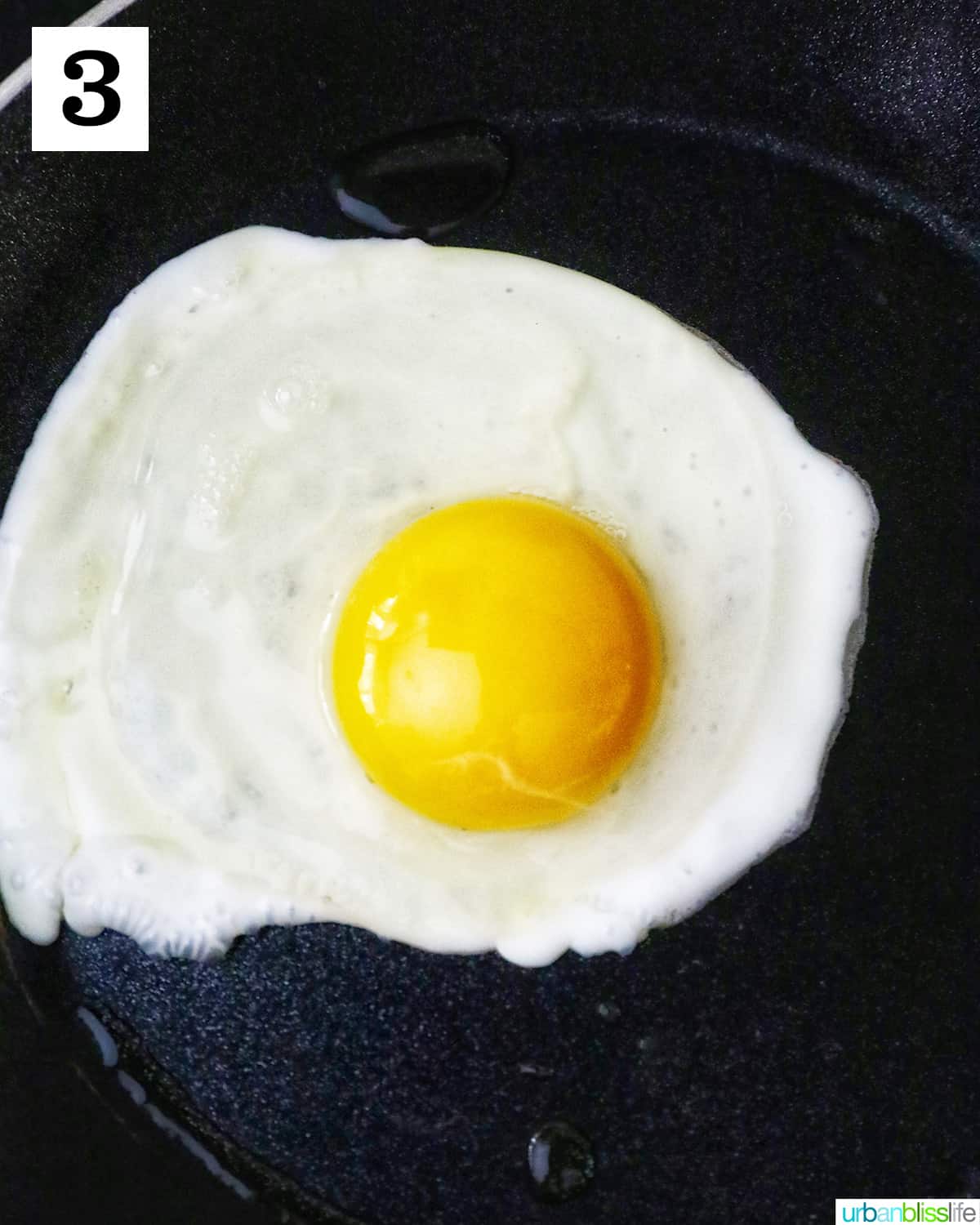 Egg over easy frying in a nonstick skillet.