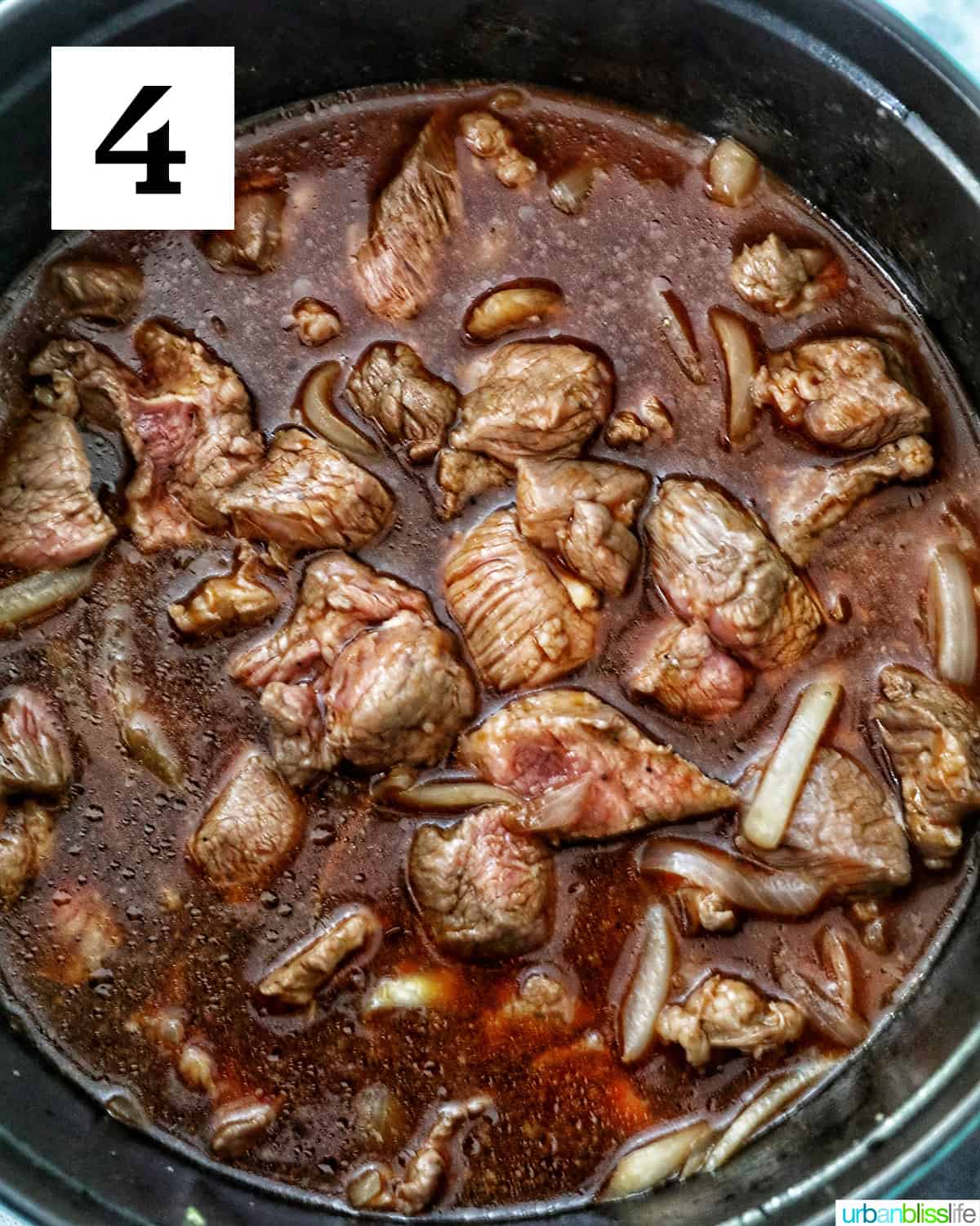 added liquids of broth, soy sauce, calamansi juice to the beef mechado in a dutch oven.