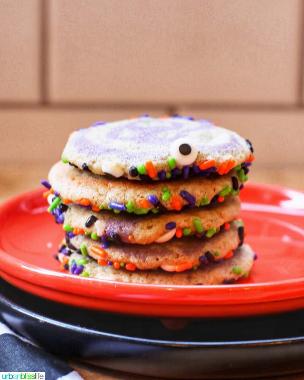 pinwheel cookies in a stack with sprinkles.