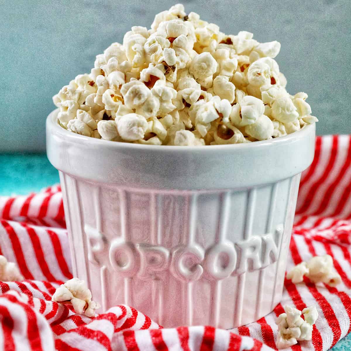 white popcorn bowl full of Instant Pot Popcorn on a red and white napkin.
