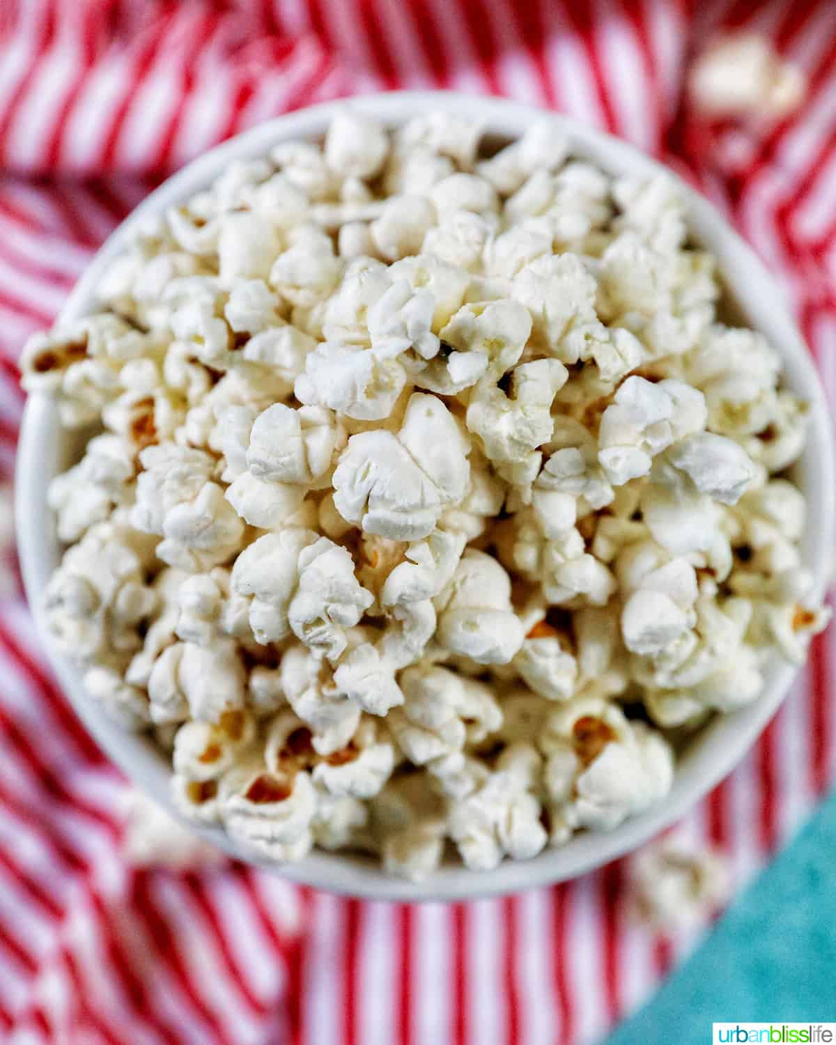 overhead photo of white popcorn bowl full of Instant Pot Popcorn on a red and white napkin.
