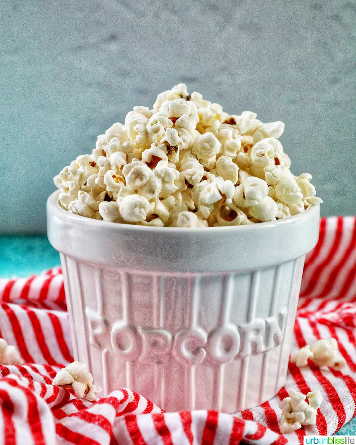white bowl of Instant Pot Popcorn on a red and white striped napkin.