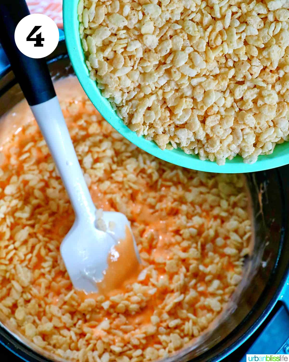 adding rice krispies cereal to orange marshmallow mix.