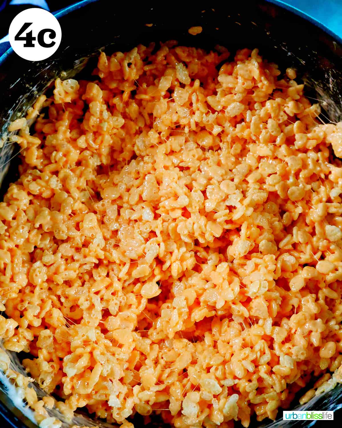 orange colored rice krispies in a dutch oven.