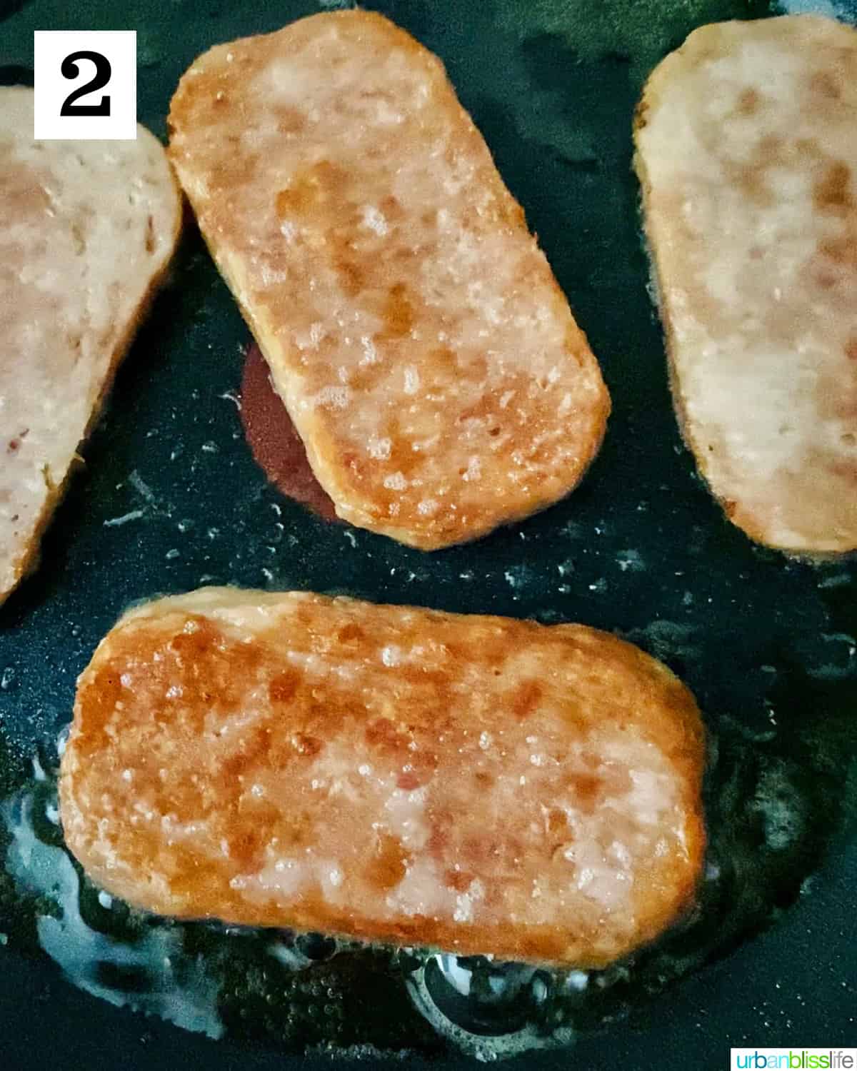 Spam slices frying in a nonstick skillet