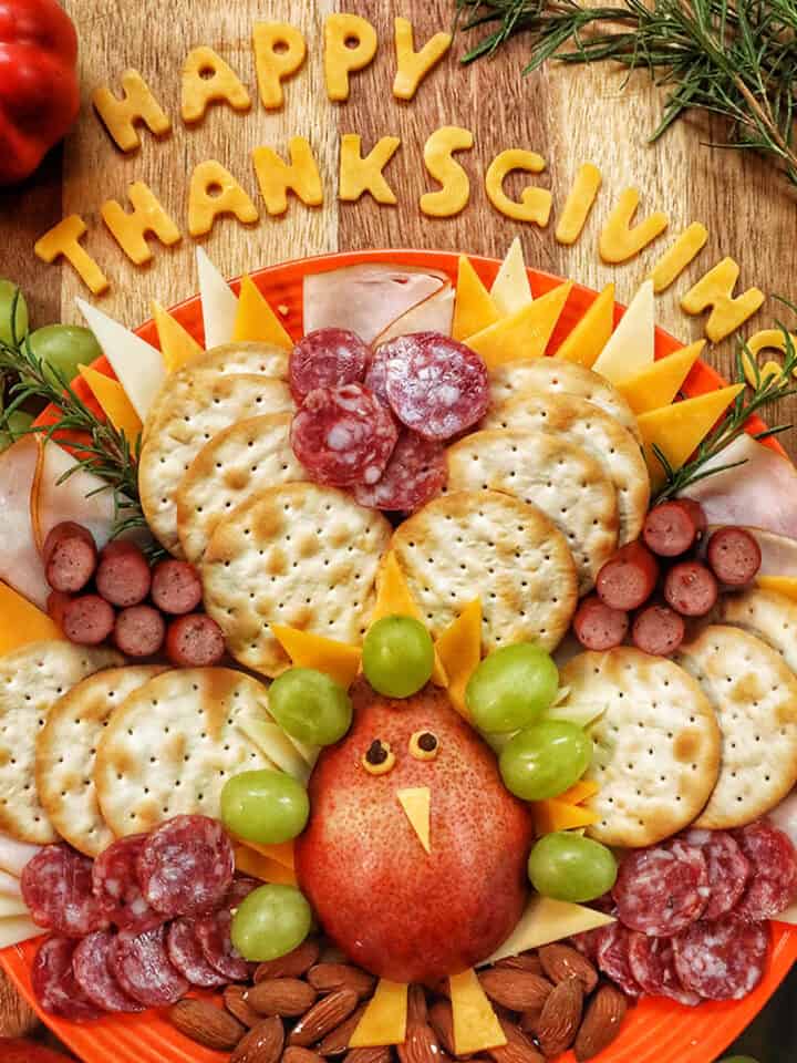 beautiful Thanksgiving turkey charcuterie board with cheese, meat, crackers, and fruit.