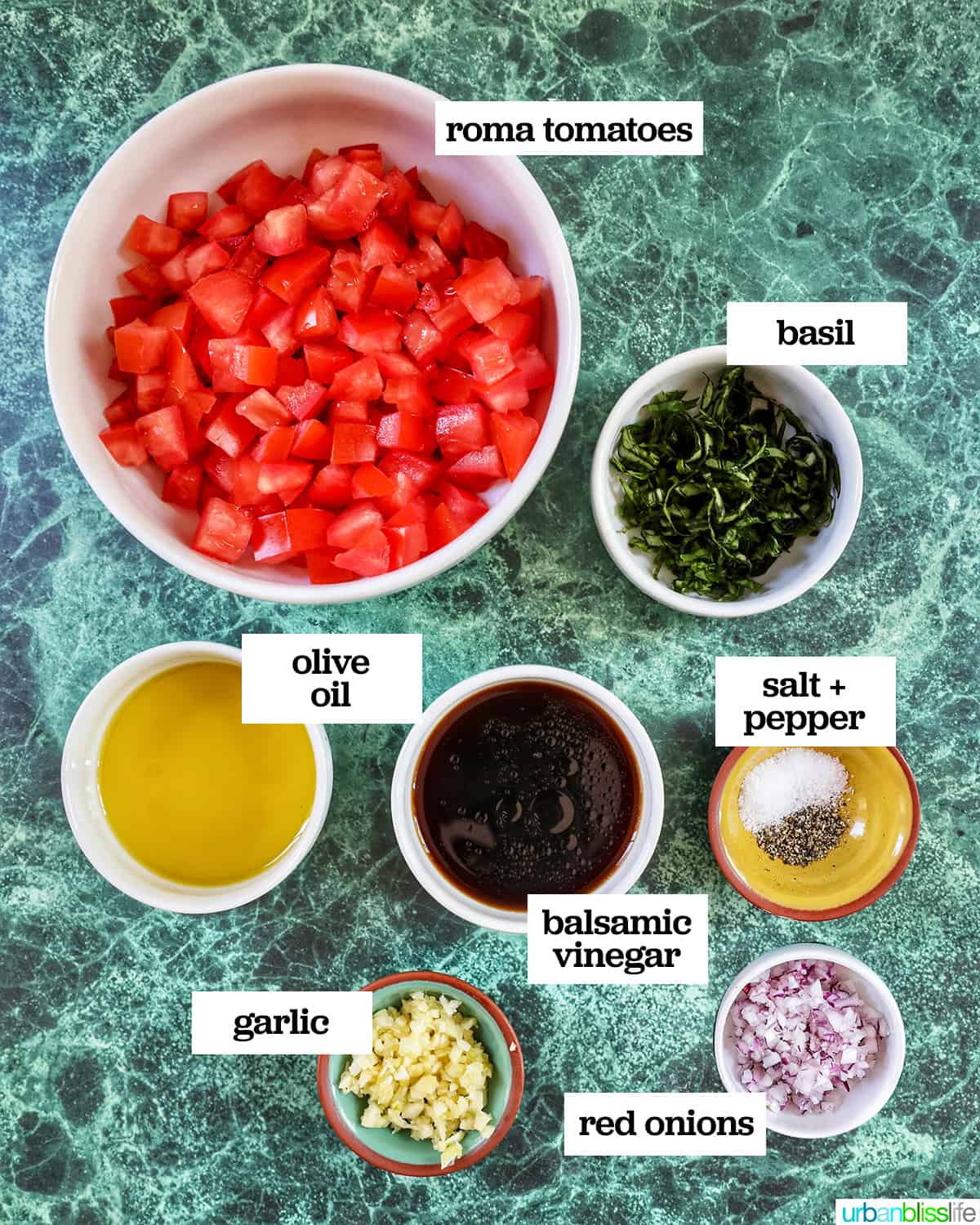 ingredients to make bruschetta chicken on a green table.