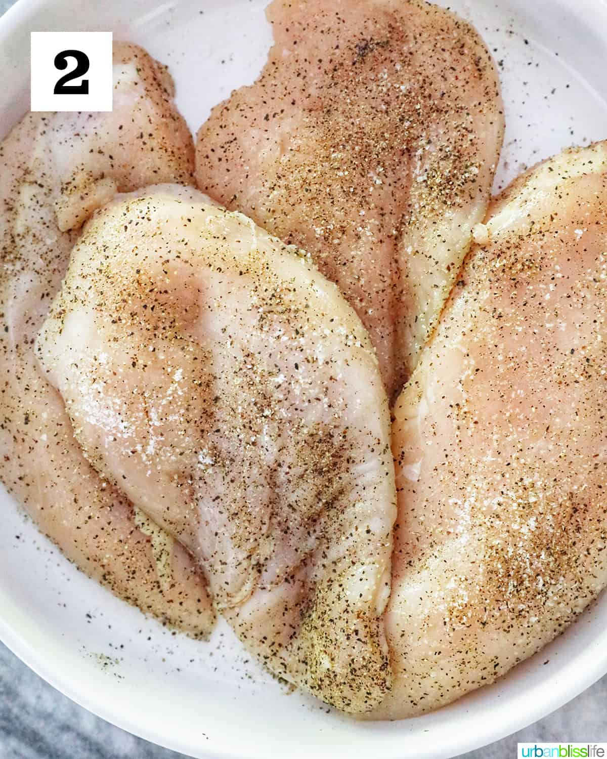four chicken breasts seasoned with salt and pepper.